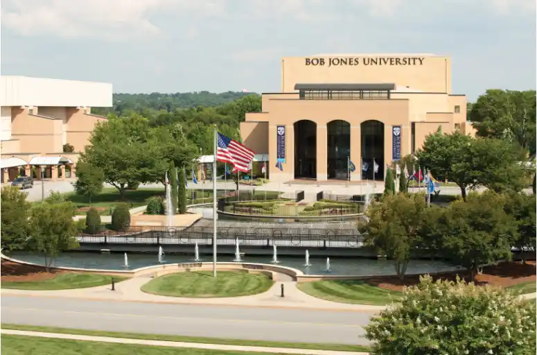 Bob Jones University campus with a fountain, American flag, and main building in view.